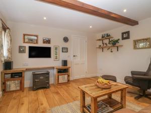 a living room with a television and a table at The Nest at the Round House in Warminster