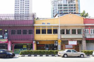 una calle de la ciudad con coches estacionados frente a los edificios en Hotel 3WINZ, en Kuala Lumpur