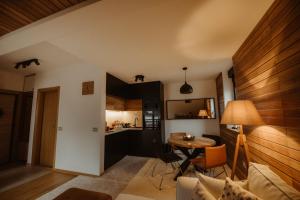 ein Wohnzimmer mit einem Tisch und einer Küche in der Unterkunft WonderWood View Apartment in Zlatibor