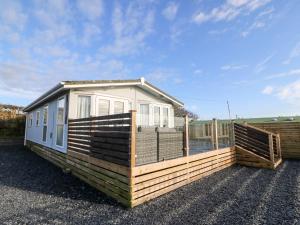 a tiny house sitting on top of a gravel lot at Caban Tywod in Pwllheli