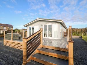 a wooden deck with a small house on it at Caban Tywod in Pwllheli