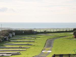 a row of bleachers on a field with the ocean in the background at Caban Tywod in Pwllheli
