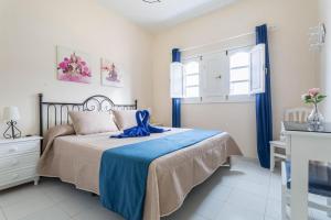 a bedroom with a bed with a blue blanket at El Sombrerito 2 in Caleta de Sebo