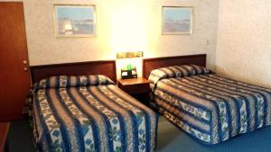 A bed or beds in a room at Budget Host Inn