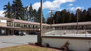 Un estacionamiento vacío frente a un edificio en Budget Host Inn, en Bedford