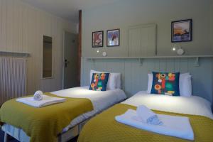 two beds with towels on them in a room at Vert Lodge Chamonix in Chamonix-Mont-Blanc
