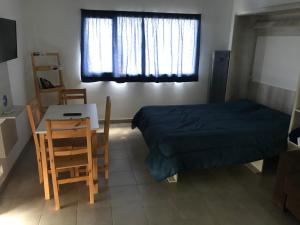 - une chambre avec un lit, une table et des chaises dans l'établissement Vistas de la meseta Patagónica, à Trelew