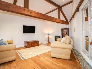 a living room with two couches and a tv at Dovecote Field House Farm in Newark upon Trent