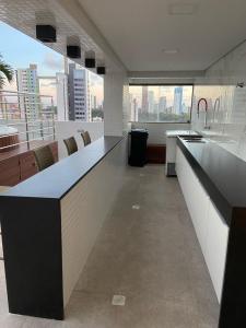 a kitchen with a counter and a view of the city at GOLD FLAT MANAÍRA 1705 in João Pessoa