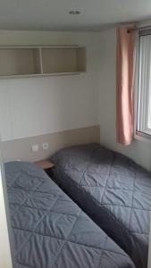 a small bedroom with two beds and a window at luminosa in Litteau