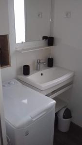 a white bathroom with a sink and a mirror at luminosa in Litteau