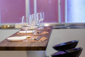 a row of wine glasses on a wooden table at Villa RAKUWA Bettei in Fujikawaguchiko