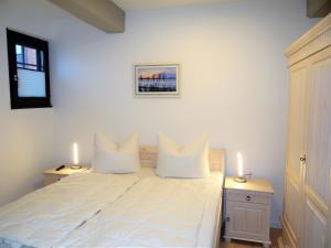 een wit bed met twee witte kussens erop bij Speicher Residenz Barth E2 App 3 in Barth