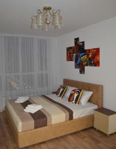 1 dormitorio con cama y lámpara de araña en In the sky apartment Kyiv, en Kiev