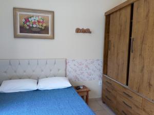 1 dormitorio con 1 cama y puerta de madera en Pousada Vila Real Flats, en Ouro Preto