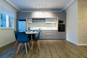 cocina con mesa y sillas azules en Apartamenty Spokojna 24C en Wisła