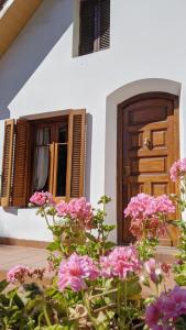 a house with pink flowers in front of a door at Hostel Sauce in Mar del Plata