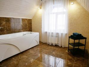 a large bathroom with a tub and a window at Добрый дом in Yegor'yevsk