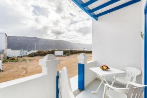 a balcony with a table and chairs and a view of the desert at El Sombrerito 2 in Caleta de Sebo