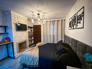 a bedroom with a large bed and a fireplace at Recanto Bella Fonte in Monte Verde