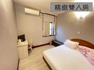 a small room with a bed and a telephone at Yi Mei Hotel in Jinshan