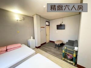 a small room with a bed and a tv at Yi Mei Hotel in Jinshan