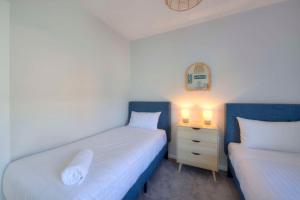 a bedroom with two beds and a night stand with two lamps at Archella 1 in Coles Bay