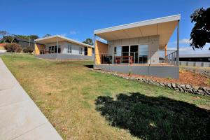 a house with a large yard in front of it at Archella 1 in Coles Bay +3 photos