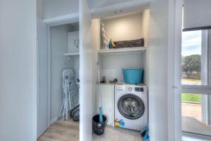 a laundry room with a washing machine in a room at Archella 1 in Coles Bay