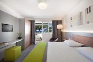 a hotel room with a bed with a green rug at Maistra Select Pineta Hotel in Vrsar