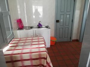 een kleine keuken met een wastafel en een tafel bij Velas de S. Jorge AL 235 in Lajes das Flores