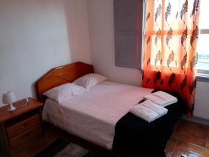 een kleine slaapkamer met een bed en een raam bij Velas de S. Jorge AL 235 in Lajes das Flores