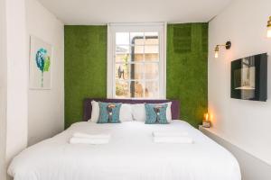 a bedroom with a large white bed with green walls at Mr Darcy's Residence in Bath