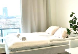 a white bed in a room with a window at City Home Finland Tampella - City View, Own SAUNA, One Bedroom, Furnished Balcony and Great Location in Tampere