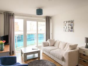 a living room with a couch and a table at Nautical Breeze in Weymouth