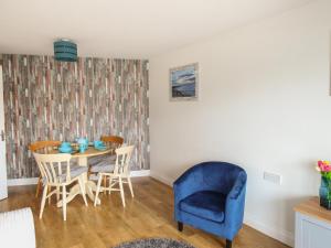 un comedor con una silla azul y una mesa en Nautical Breeze, en Weymouth 7 fotos más