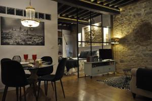 Una sala de estar con mesa y sillas y un comedor. en Lofts amantes de Toledo- LOFT ALCAZAR, en Toledo