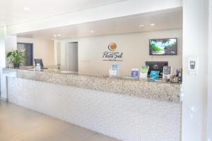 a pharmacy counter with a sign on the wall at Hotel Porto Sol Beach in Florianópolis