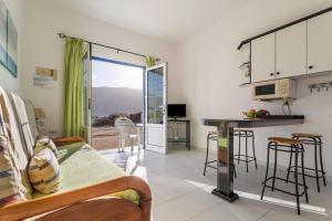 ein Wohnzimmer mit einem Bett und eine Küche mit einem Tisch in der Unterkunft El Sombrerito 1 in Caleta de Sebo