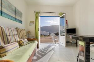 a living room with a couch and a sliding glass door at El Sombrerito 1 in Caleta de Sebo