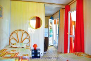 1 dormitorio con 1 cama y puerta a un balcón en Bungalow - Type F3 - plage de petite anse en Bouillante
