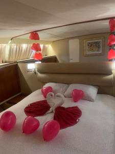 a bed with pink hearts and balloons on it at Johnny M Yacht in Taʼ Xbiex