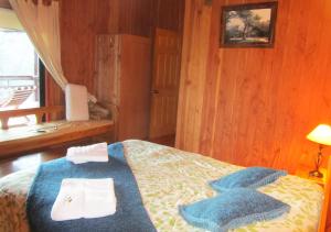 1 dormitorio con 1 cama con toallas en Mirador Los Volcanes Lodge & Boutique, en Pucón