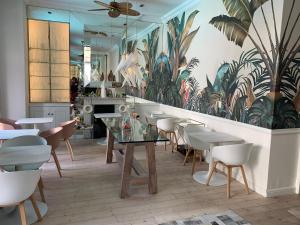 un restaurante con mesa, sillas y un mural en Mountview Guest House, en Ciudad del Cabo