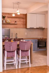 una cucina con sedie viola su un'isola cucina di RUPE Apartments - FREE PARKING in city center! a Ohrid