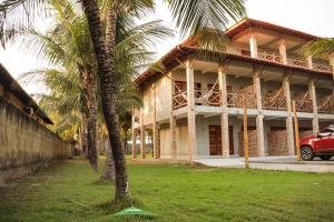 a building with palm trees in front of it at Orla Piaui in Luis Correia