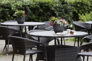 two tables and chairs with flowers on top of them at Scandic Aalborg City in Aalborg