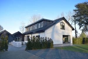 a white house with a black roof at 28-persoons Groep Villa in Voorthuizen