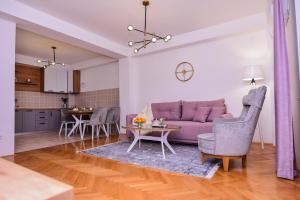 een woonkamer met een paarse bank en een tafel bij RUPE Apartments - FREE PARKING in city center! in Ohrid