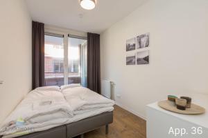 Bett in einem Zimmer mit Fenster in der Unterkunft 3-persoons comfort appartement in Zoutelande